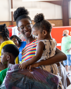 Mother holds her daughter at the Back to School Expo.