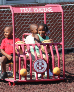 Children at play in a playground fire truck.