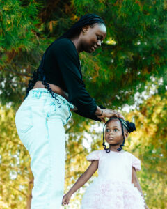 Women braids her daughters hair.
